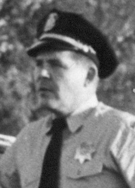 Historic black-and-white portrait of a uniformed police chief wearing a peaked cap.